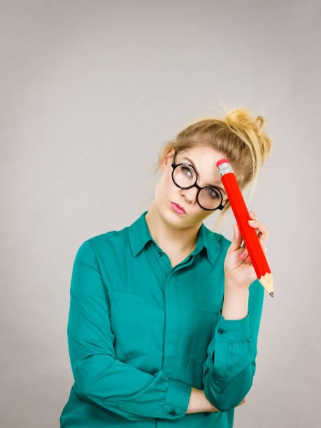 istock Woman confused thinking, big pencil in hand 945147928