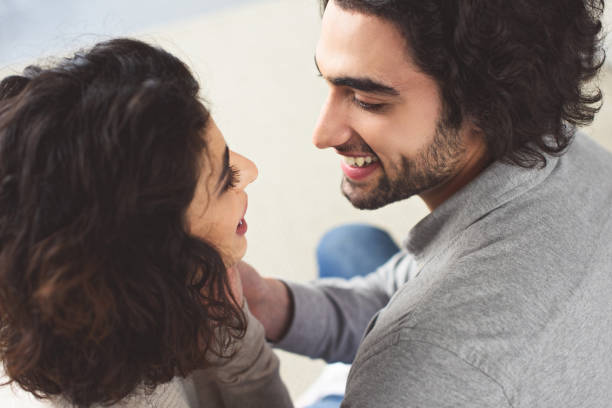 istock affectionate young couple hugging and looking at each other at home 945148266