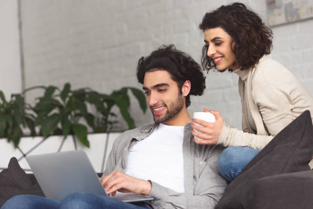 istock young couple using laptop at home 945148496