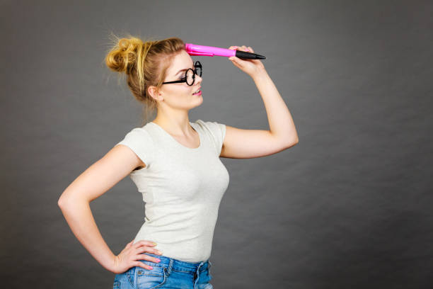 istock Woman holding big oversized pencil thinking about something 945148622