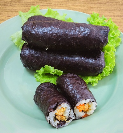 Japanese Cuisine, Traditional Vagetarian Japanese Rice Maki Sushi Roll Stuff with Tofu and Carrot Wrapped in Nori Seaweed.