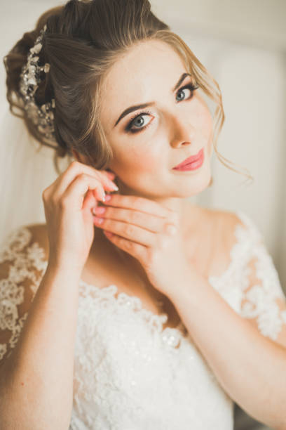 istock Luxury bride in white dress posing while preparing for the wedding ceremony 945151878