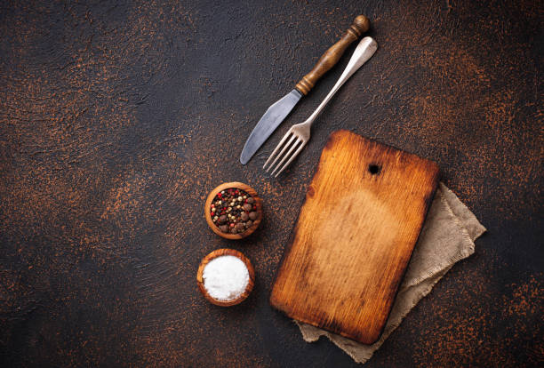 istock Empty vintage cutting board with spices and cutlery 945152210