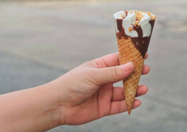 istock Hand Holding Ice Cream Cones with Chocolate 945152254