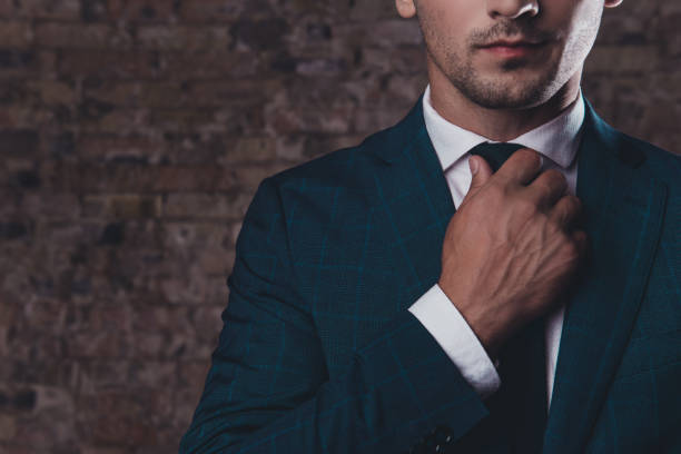 istock Close up of stylish man in black suit correcting tie 945155374