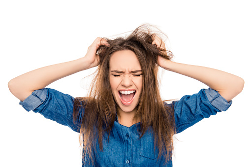 Angry sad young woman with damaged hair screaming