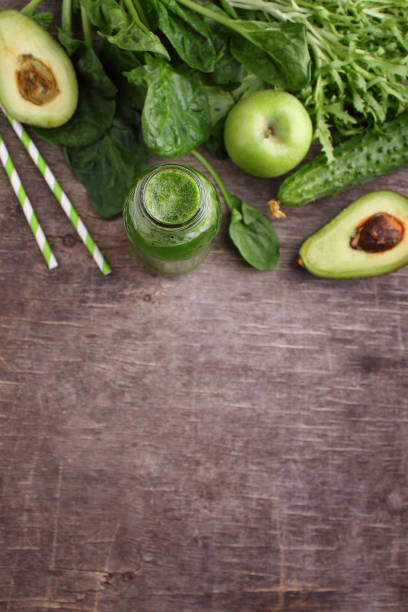 istock healty green vegetable: spinach, cucumber, lettuce, apple and avocado on dark background 945156020