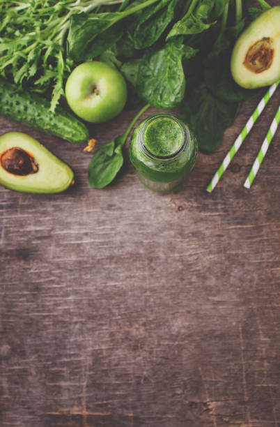istock healty green vegetable: spinach, cucumber, lettuce, apple and avocado on dark background 945156112