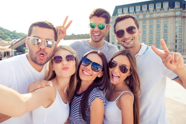 istock Six happy successful young people having fun and making selfie 945159248