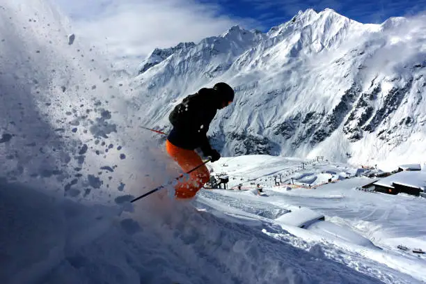 Male extreme skier riding backcountry in the deep snow on a sunny day in St. Anton, Austria