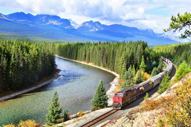 Canadian Pacific Railway in Banff National Park,Canada. Long freight train Canadian Pacific Railway (CPR) moving along Bow river in Canadian Rockies ,Banff National Park, Canadian Rockies,Canada. canadian rockies stock pictures, royalty-free photos & images