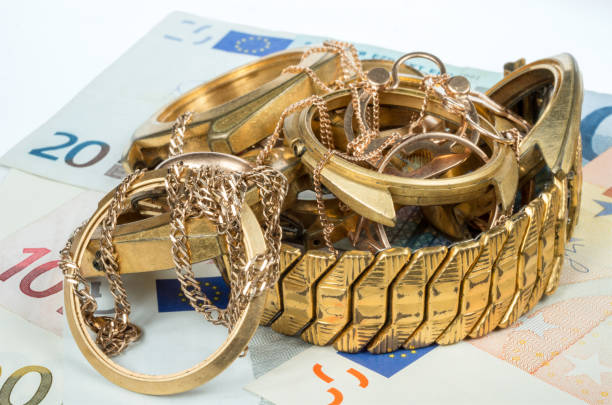 un pezzo d'oro. gioielli vecchi e rotti, orologi d'oro e d'oro placcati su uno sfondo di banconote in euro. - scrap gold immagine foto e immagini stock