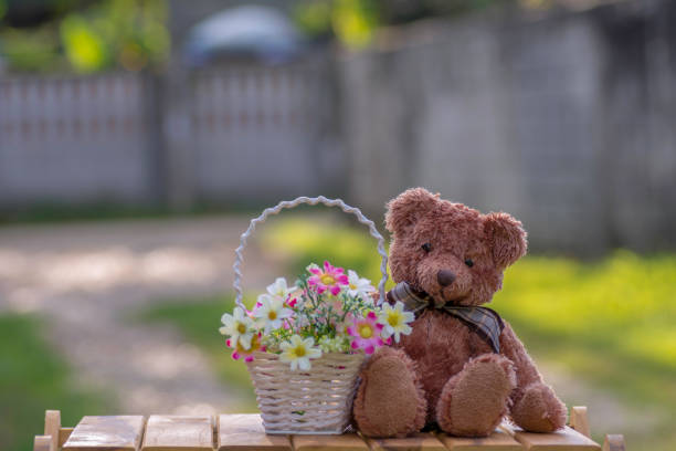 istock Teddy bear in a basket of flowers. 945184506