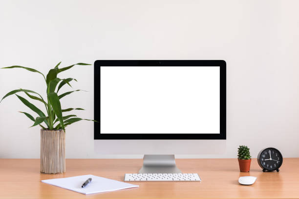 istock All in one computer, mouse, keyboard, paper, pen, cactus and tree vase  on wooden table 945192024