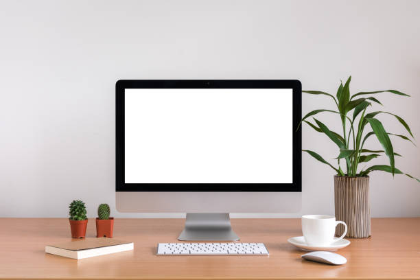 istock All in one computer, mouse, keyboard, cactus, tree vase and coffee cup  on wooden table 945192044