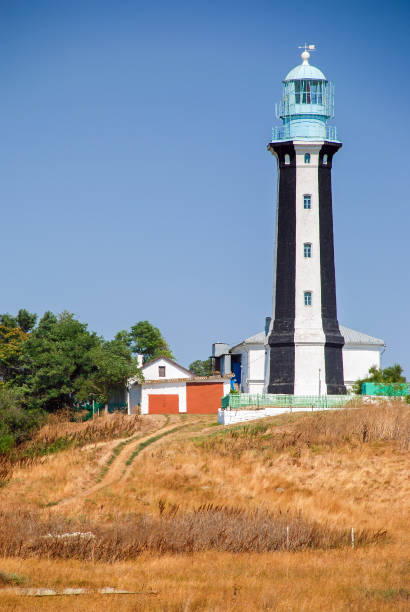 istock Lighthouse searchlight beam through sea air at night. Seascape at sunset 945196930