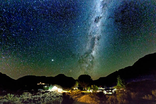 Starry night over campsite Stars including dramatic Milky Way soar above a well-lit campsite. cederberg mountains photos stock pictures, royalty-free photos & images