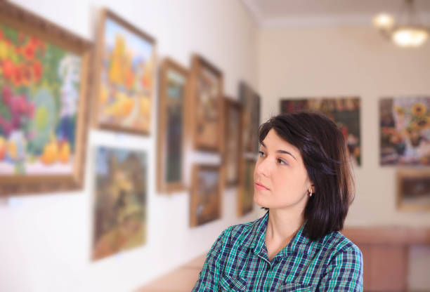 istock Young woman looking at painting. 945200654