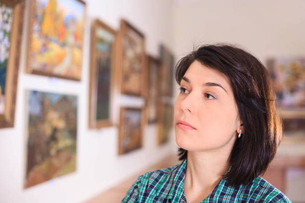istock Young woman looking at painting. 945200682