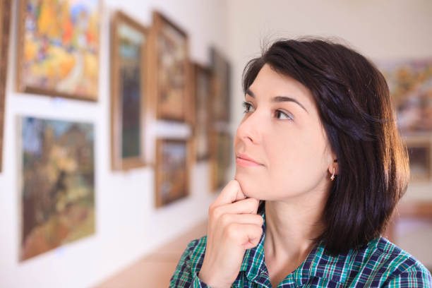 istock Young woman looking at painting. 945200738