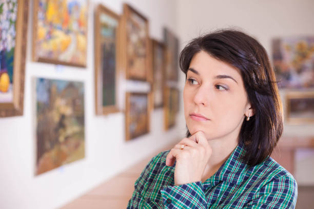 istock Young woman looking at painting. 945200782