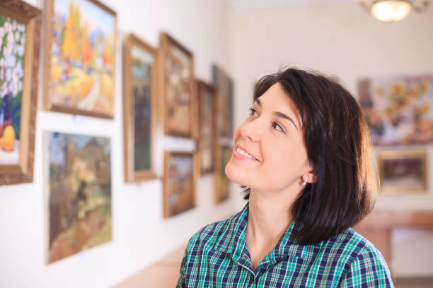 istock Young woman looking at painting. 945200828