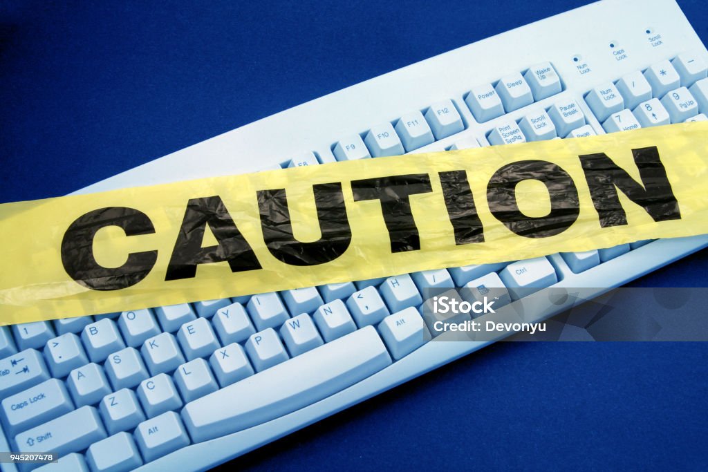 computer crime plastic caution tape and keyboard, computer crime Barricade Tape Stock Photo