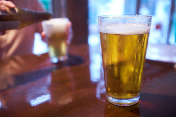 istock Glass of beer against standing on table 945210654