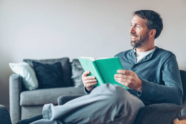 istock Happy man with book at home 945212766