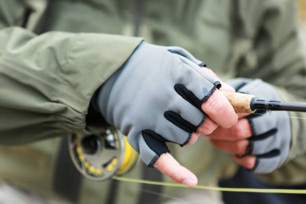 Man wearing fingerless gloves for fly fishing stock photo