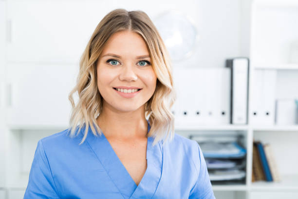 istock Kindly woman in doctor's uniform greets visitors at modern office 945218932