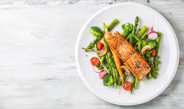 Roasted salmon steak with asparagos broccoli carrot tomatoes radish green beans and peas. Fish meal with fresh vegetable Roasted salmon steak with asparagos broccoli carrot tomatoes radish green beans and peas. Fish meal with fresh vegetable. asparagus photos stock pictures, royalty-free photos & images