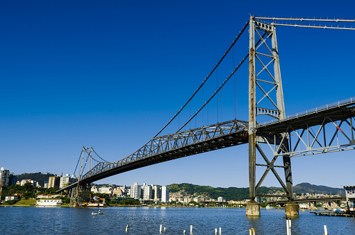Bridge Hercilio Luz in Florianopolis Santa Catarina view from the mainland to the island, photo with sea and blue sky during the day.