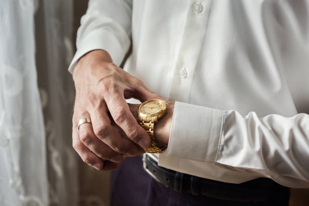 istock businessman checking time on his wrist watch, man putting clock on hand,groom getting ready in the morning before wedding ceremony 945237384