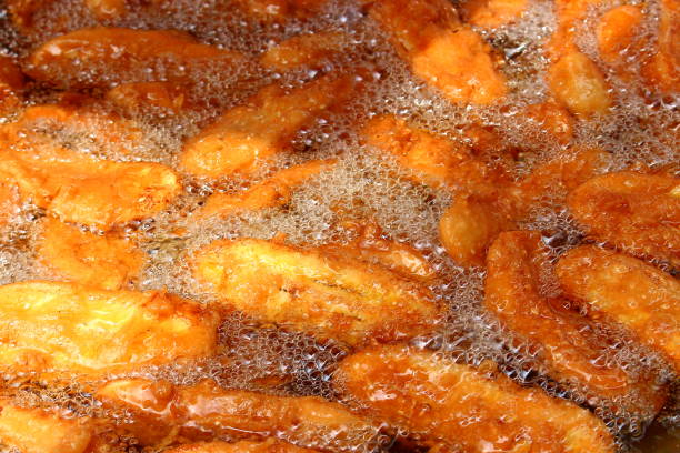 Bananas in batter are fried in vegetable oil. Authentic Thai street dessert as concept background