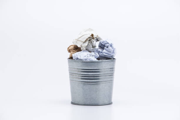istock Crumpled business papers with metal pot concept view on white 945258808