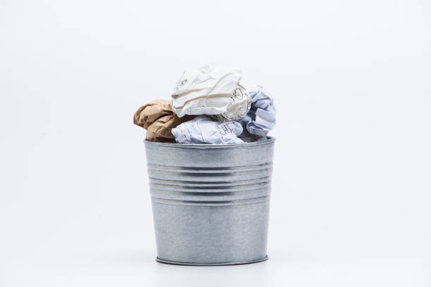 istock Crumpled business papers with metal pot concept view on white 945258820