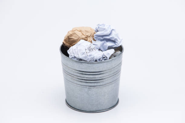 istock Crumpled business papers with metal pot concept view on white 945258822