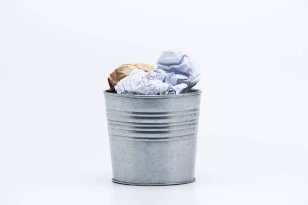 istock Crumpled business papers with metal pot concept view on white 945258834