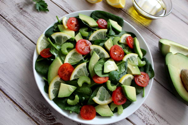 istock Avocado salad with vegetables on a wooden background. 945259066