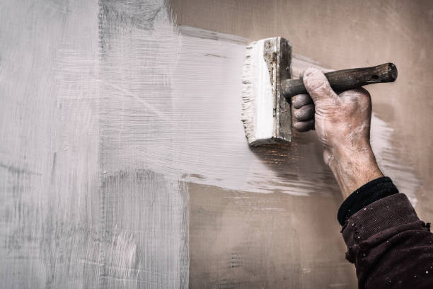 istock Master prime a putty wall before applying a decorative layer of plaster, repairs work in the house, second stage, with noise effect 945259154