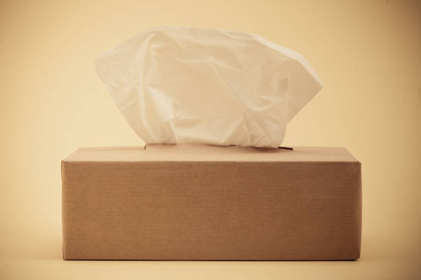 istock Paper tissues in brown box on yellow background 945260890