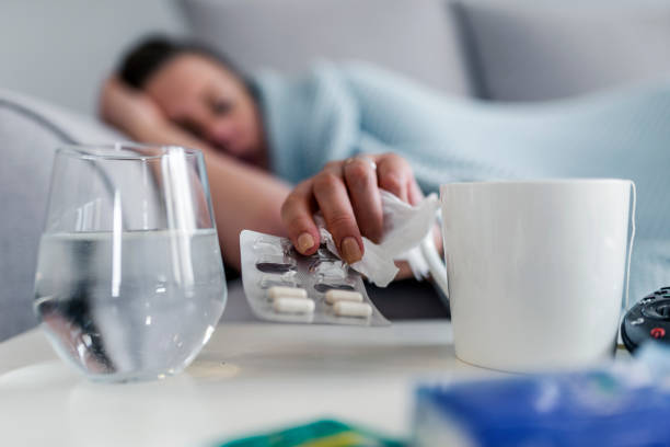 Seeking relief from pain Unhealthy sick Caucasian woman suffers from insomnia or headache during the day, takes sleeping pill while laying in bed with glass of water, depressed girl holds antidepressant medications, painkiller for menstrual pain, close up. Photo of Stressed woman drinking pill or medicine with glass of water on bed at home after wake up in the morning sleeping pill stock pictures, royalty-free photos & images