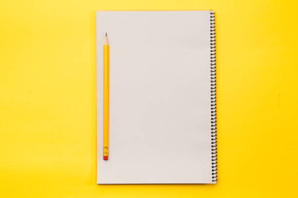 istock Blank note book with yellow pencil on yellow background 945263672