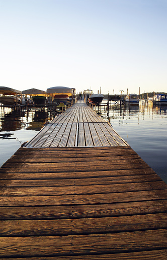 Camera angle gives the appearance of a very long boat dock on Chautauqua Lake in early evening