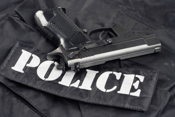 istock handgun on police black uniform background 945281696