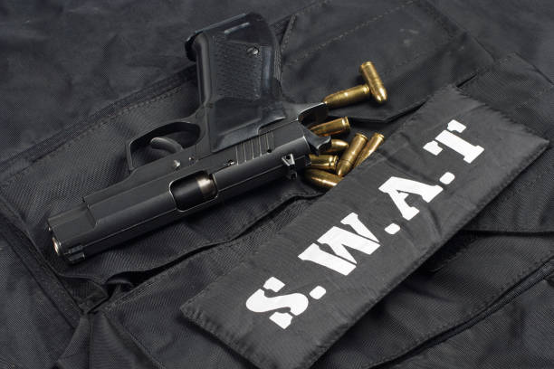 istock handgun on SWAT black uniform background 945281832