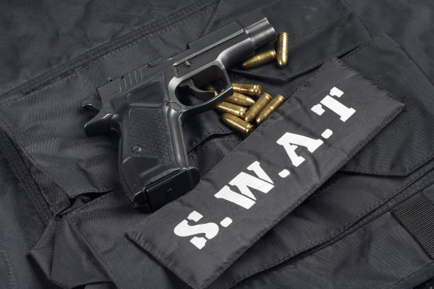 istock handgun on SWAT black uniform background 945281844