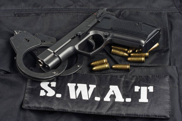 istock handgun on SWAT black uniform background 945281940