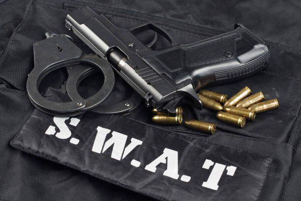 istock handgun on SWAT black uniform background 945281976